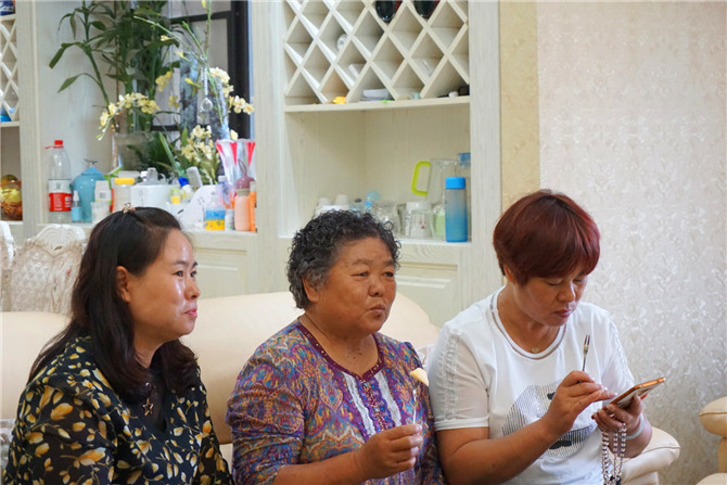 李瓊芳（中）與大女兒（右）、三女兒（左）在家里看電視。記者勞學(xué)麗 攝