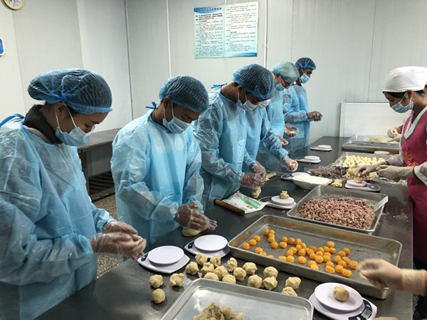 4 外國友人們在烘焙師傅的指導(dǎo)下有模有樣地制作月餅。 記者蘇雯芊 攝